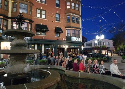 Group picture of tourist sitting around the DePasquale Square, Providence, RI, taken during the An Evening in the City Tour.