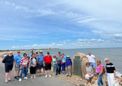 Group picture of tourists at the Settlers' Rock - a destination included in the Beautiful Block Island - Mancini Center Tour.