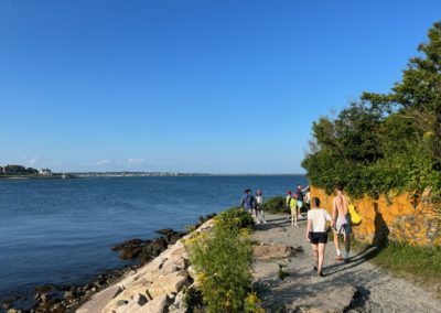 Tourists walking on the road along the Cliff Walk.