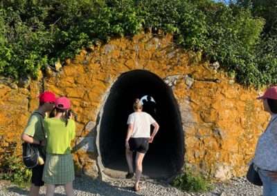 Four children about to go inside the tunnel on the trail of Cliff Walk in Newport, RI.