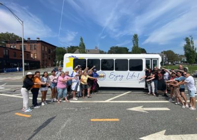 Group picture of tourists with the Experience RI Tour Bus - an experience included in the Discover Providence Tour.