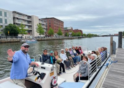 Tourists on board a cruise for a boat tour around Providence River - included in the Providence-by-Road-and-by-River Tour.