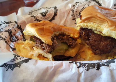 2 burgers on a plate with wrapper by Harry's Bar & Burger - a meal included in the Providence's Very Delicious Lunch Tour.