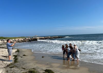 A guy taking pictures of a family at the Napatree Point Beach - a destination included in the Scenic Rhode Island Tour.