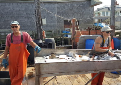 Twto fishermen showing their catch - an experience included in the Come Away to the Quiet Coast Tour.