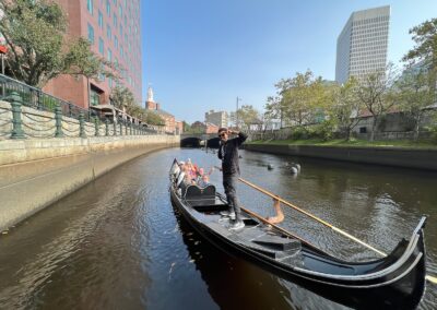 Tourists onboard a black Gondola sailing the Providence River - an activity included in the Italian Experience Tour.